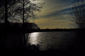 reflection of the evening sun in a dark lake