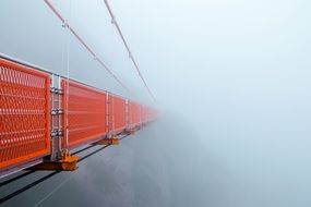 red fenced mountain Bridge in fog