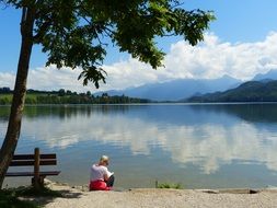 female tourist sitting by the lake Weissensee