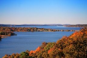 landscape of autumn forest by the lake in sunny weather