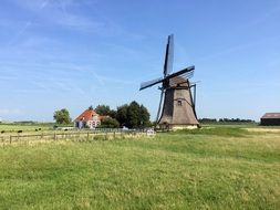 wooden mill in a wide field in the netherlands