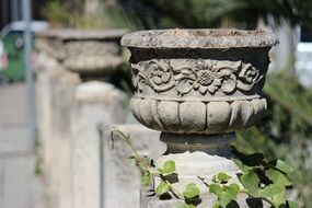heavy gray vases on a stone fence