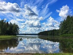 white clouds reflected in a lake in finland