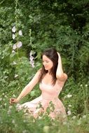 beatuful woman in the pink dress on the meadow