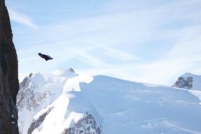 wingsuit flying at snowy aiguille du midi mountain, france, chamonix