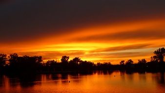 orange clouds in the sky at sunset over the lake