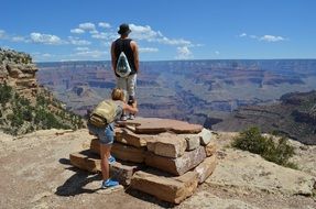 tourists take photos at the top of the canyon