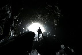 man in Cave opening on Rocks, Iceland