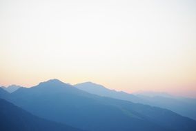 pink sky over blue mountains