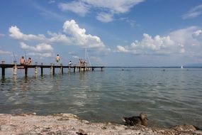 wooden pier on the lake with people