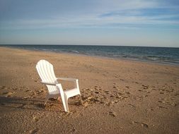 white garden chair on the beach