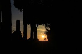 silhouette of a traveler against the bright sun at sunset