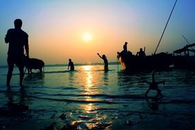 Landscape with the people on the river under the sunset