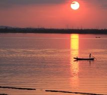 reflection of the setting sun on a pink sky in the sea