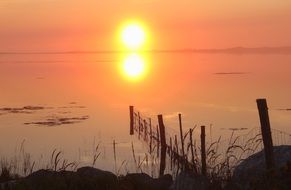 bright sun on the horizon and orange sunset over the coastline