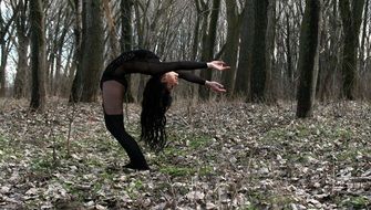 girl is doing gymnastics on the background of the autumn forest