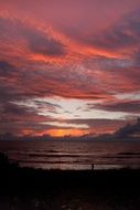 colorful Clouds in Sunset sky above dark water