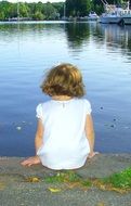 little girl with curly hair near the water