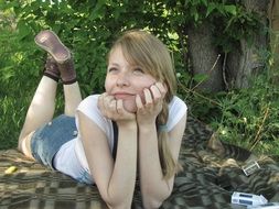 girl lies on the ground in the forest