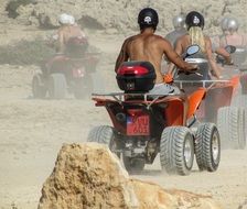 men ride buggy in the desert