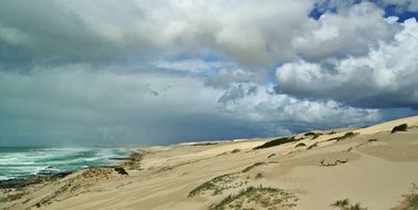 sandy beach in south africa under a cloudy sky