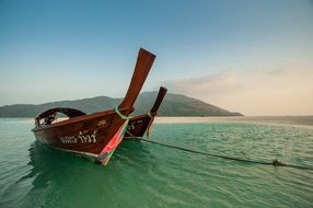 boats on calm water on the coast of thailand