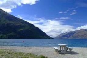 White bench on a lake bank in New Zealand