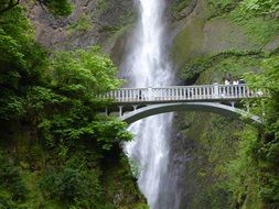 tourist bridge on the background of a waterfall