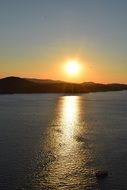 setting sun in the clear sky over the mountains