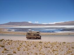Kombi van on road in desert landscape at salt lake