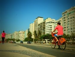 guy on an orange bike in the streets of brazil