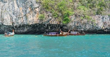 wooden boats off the rocky coast of phi phi island