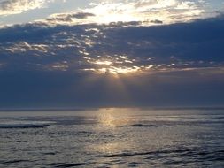 landscape of the sun at sunset over the clouds over the sea