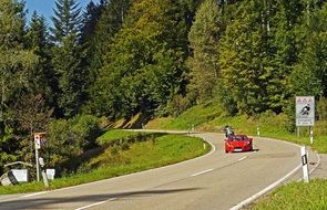 red sports car rides on the road