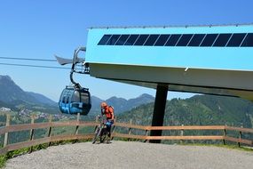 Biker near cable road station at scenic mountains