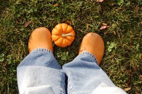 orange rubber boots on his feet and pumpkin
