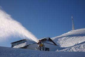 snow cannon on a ski slope on a sunny day, switzerland