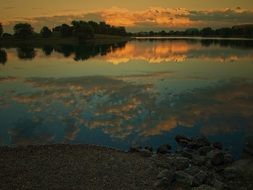 picturesque clouds are reflected in the lake at dusk