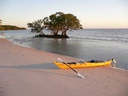 yellow kayak on the sand of the sea coast at dusk
