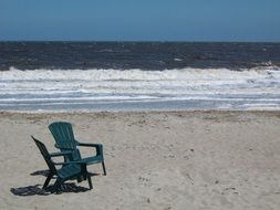 green garden chairs by the ocean on a sunny day