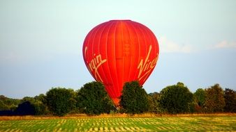 Red hot Air Balloon at harvested field