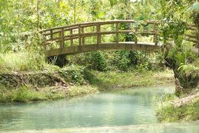 wooden foot bridge over a small pond in the park