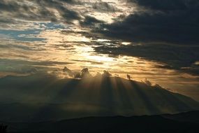 yellow sun rays of sunset in the clouds