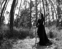 girl in long black dress in forest