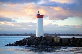 white Lighthouse on rock at blue Sea, evening Landscape, France