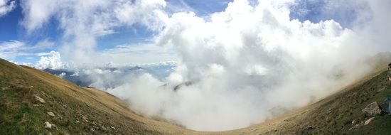 white clouds on a green valley