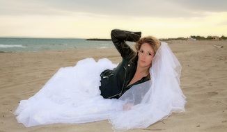 bride in a leather jacket on a sandy beach