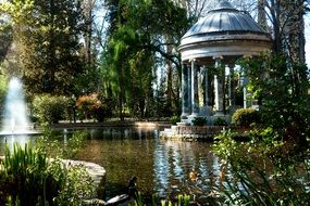 stone gazebo and fountain in the pond in the park