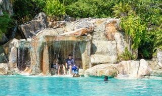 tourists under a waterfall in the Bacab jungle park