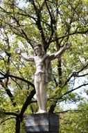 Beautiful sculpture of Jesus near the green trees